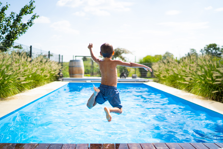 hello summer holidays - boy jumping in swimming pool