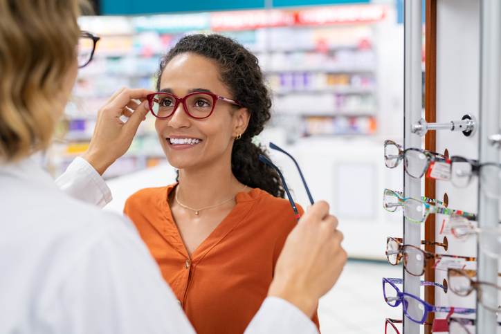 Optician comparing spectacles with client Optician comparing spectacles with client